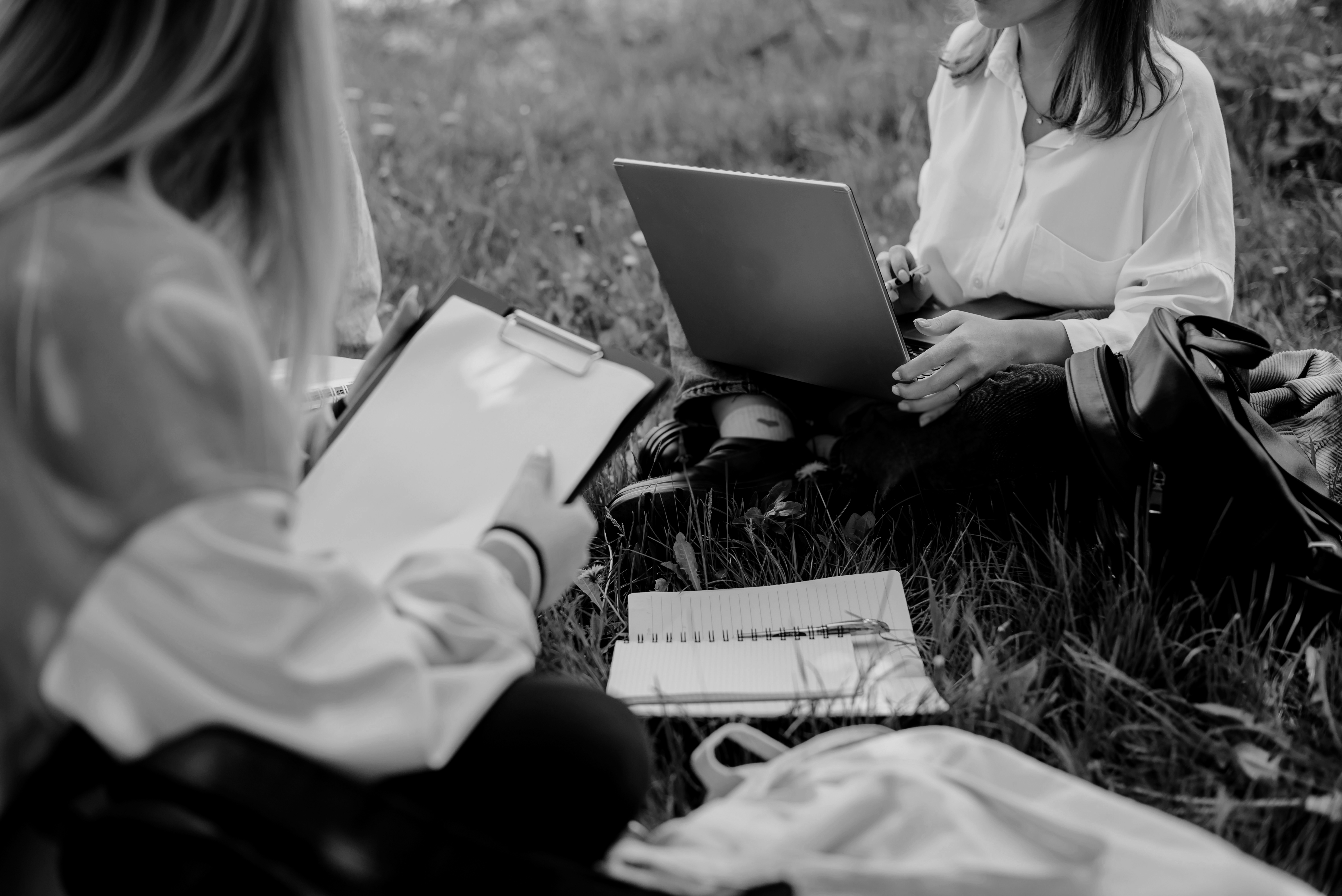 Research communities: an image of women working outside on a laptop and clipboard